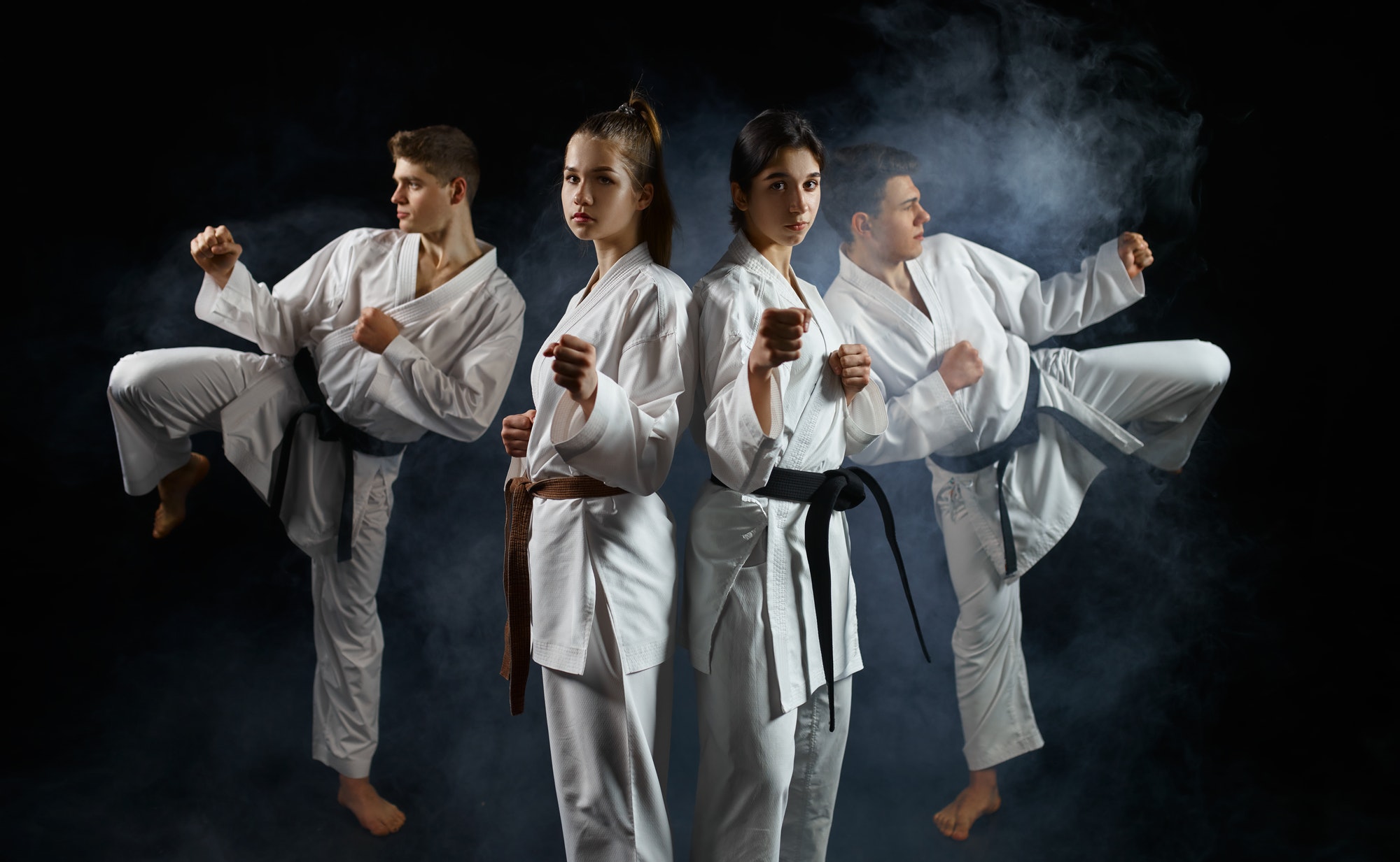 Four karate fighters in kimono, smoky background